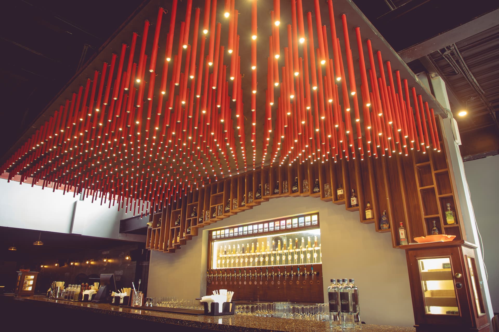 Red pendant lights suspended over the brewpub bar