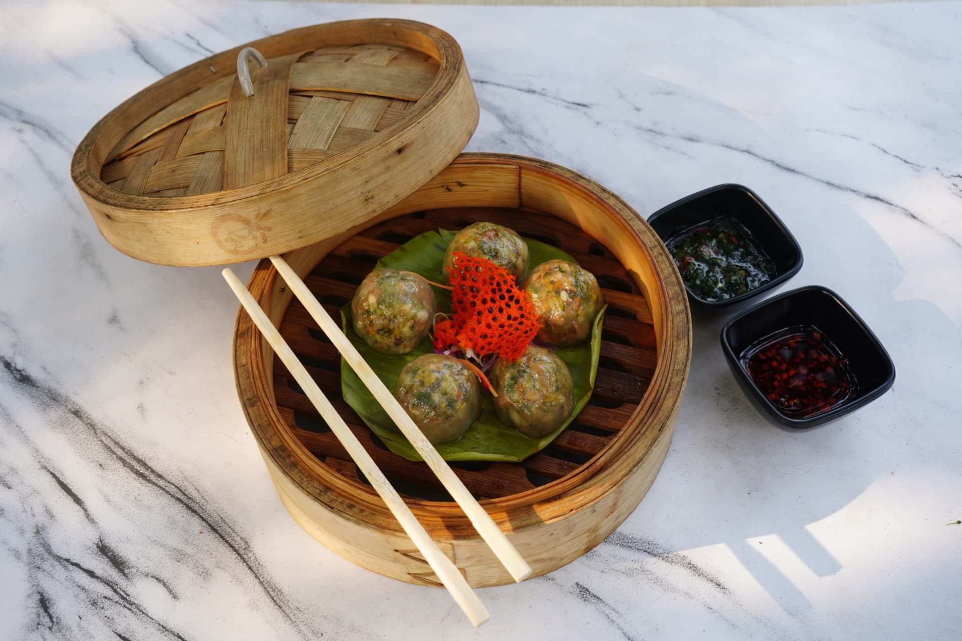 Crystal dumplings with chilli oil in a bamboo steamer
