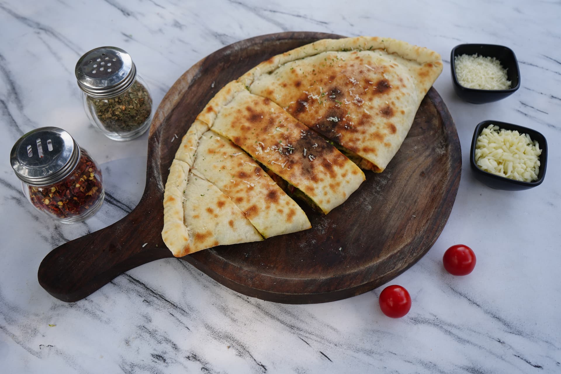 Calzone cut into slices on a wooden paddle