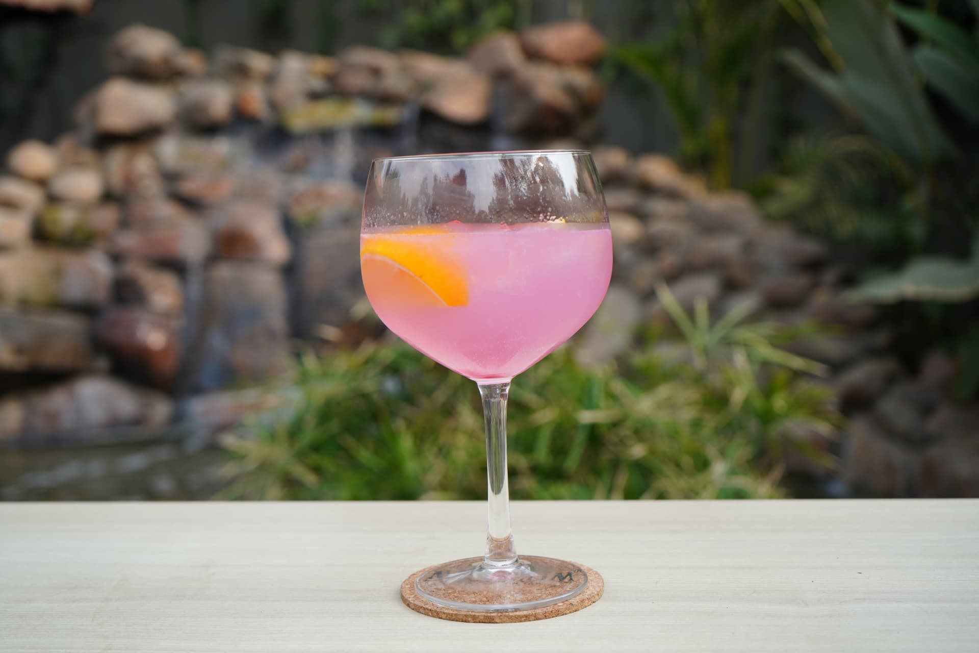 Pink gin cocktail with an orange slice