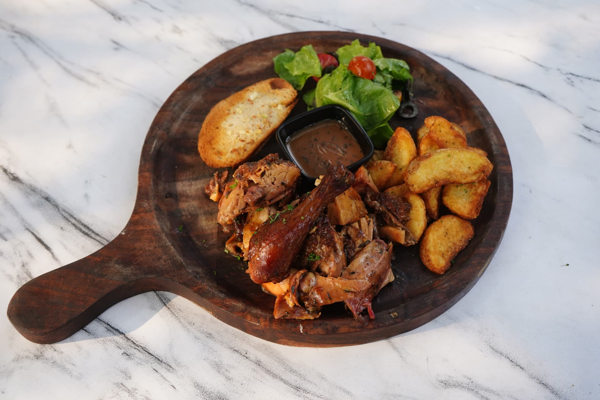 Roast chicken platter with potato wedges and garlic bread