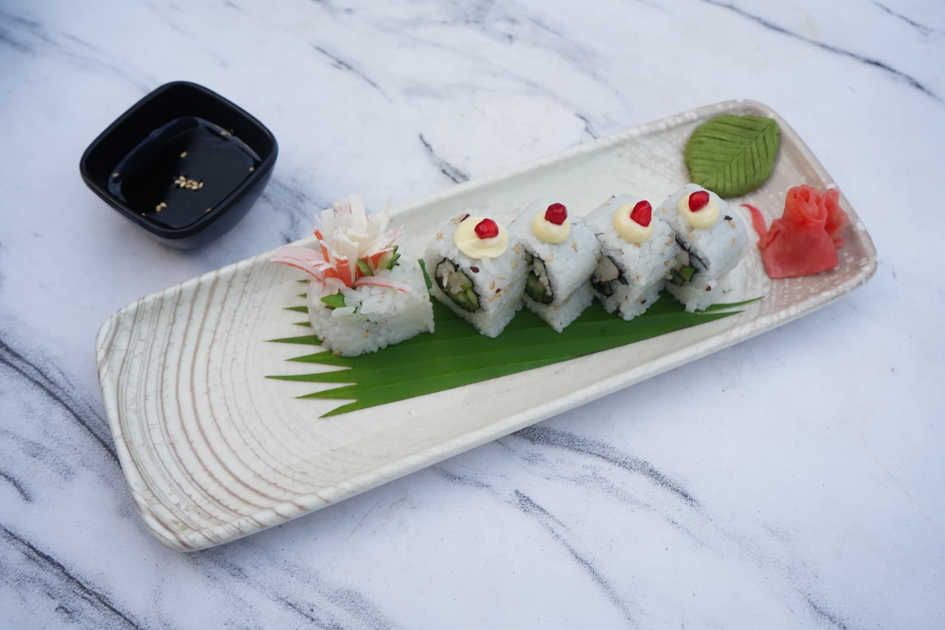 California sushi rolls plated with wasabi and pickled ginger