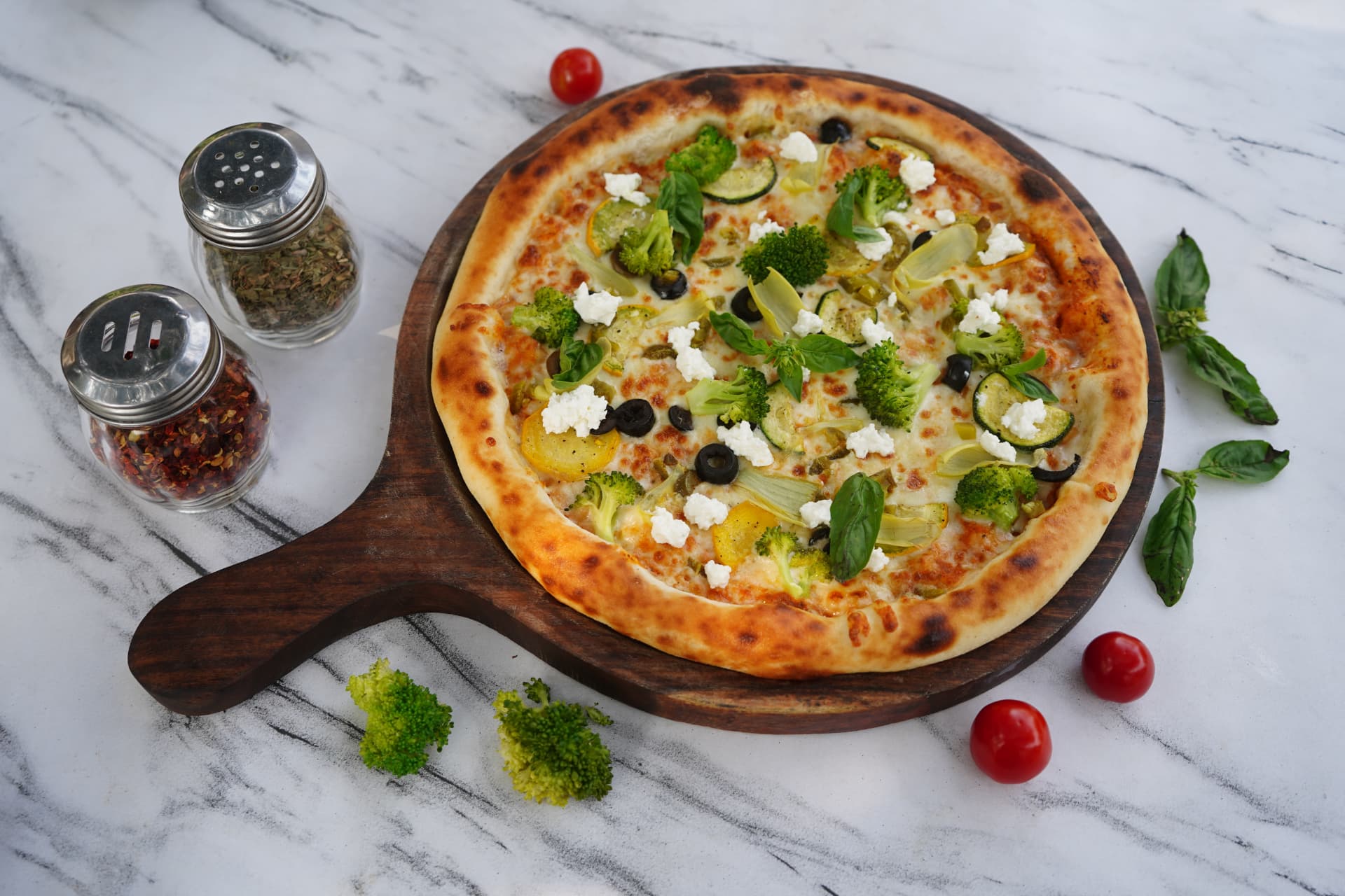 Garden pizza topped with broccoli, zucchini and feta